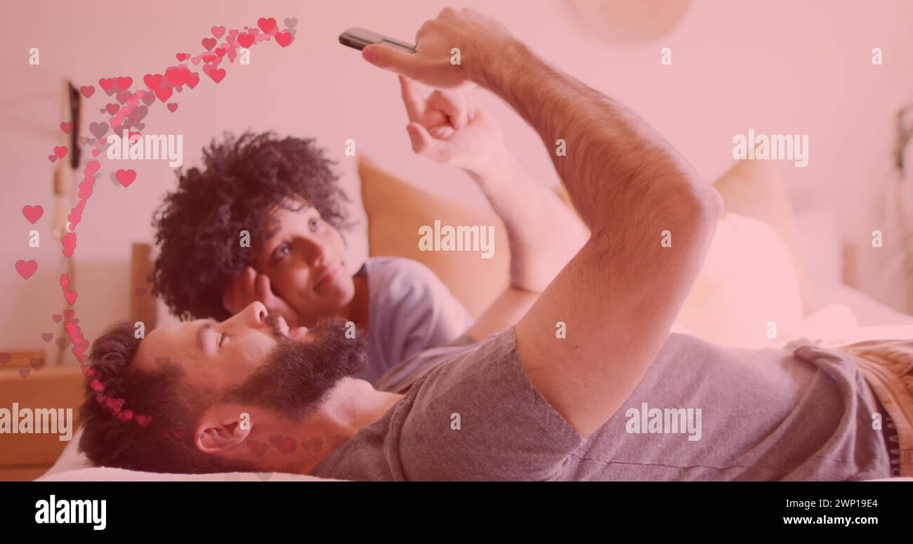 Immagine di cuori che si uniscono a una coppia diversa utilizzando lo smartphone Foto Stock