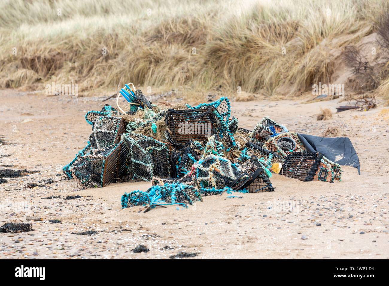 Vecchie pentole di aragosta, nasse e reti da pesca si sono accumulate su una spiaggia di North Berwick Foto Stock