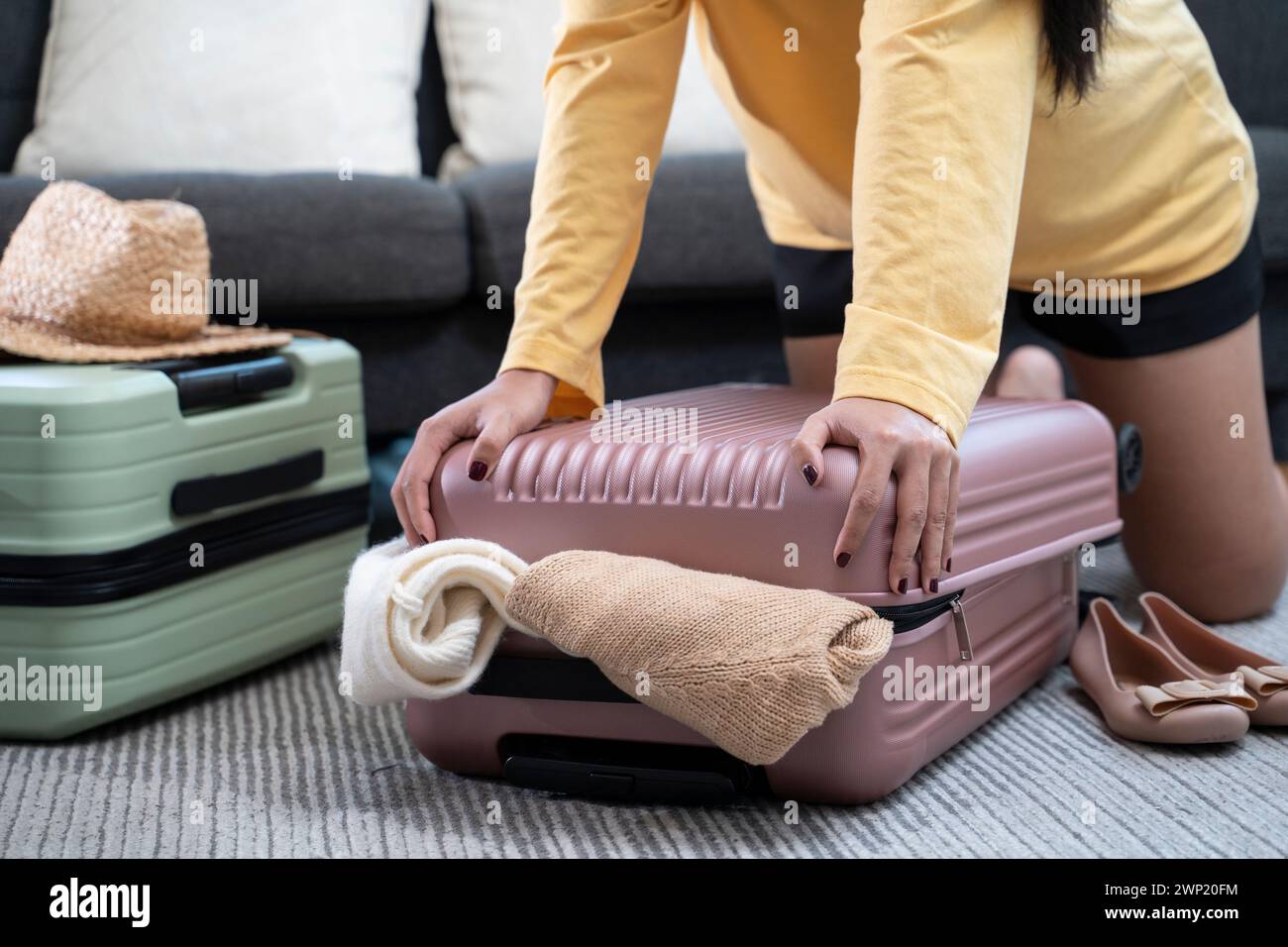 Donna che confeziona abiti in valigia per un viaggio in vacanza. Foto Stock