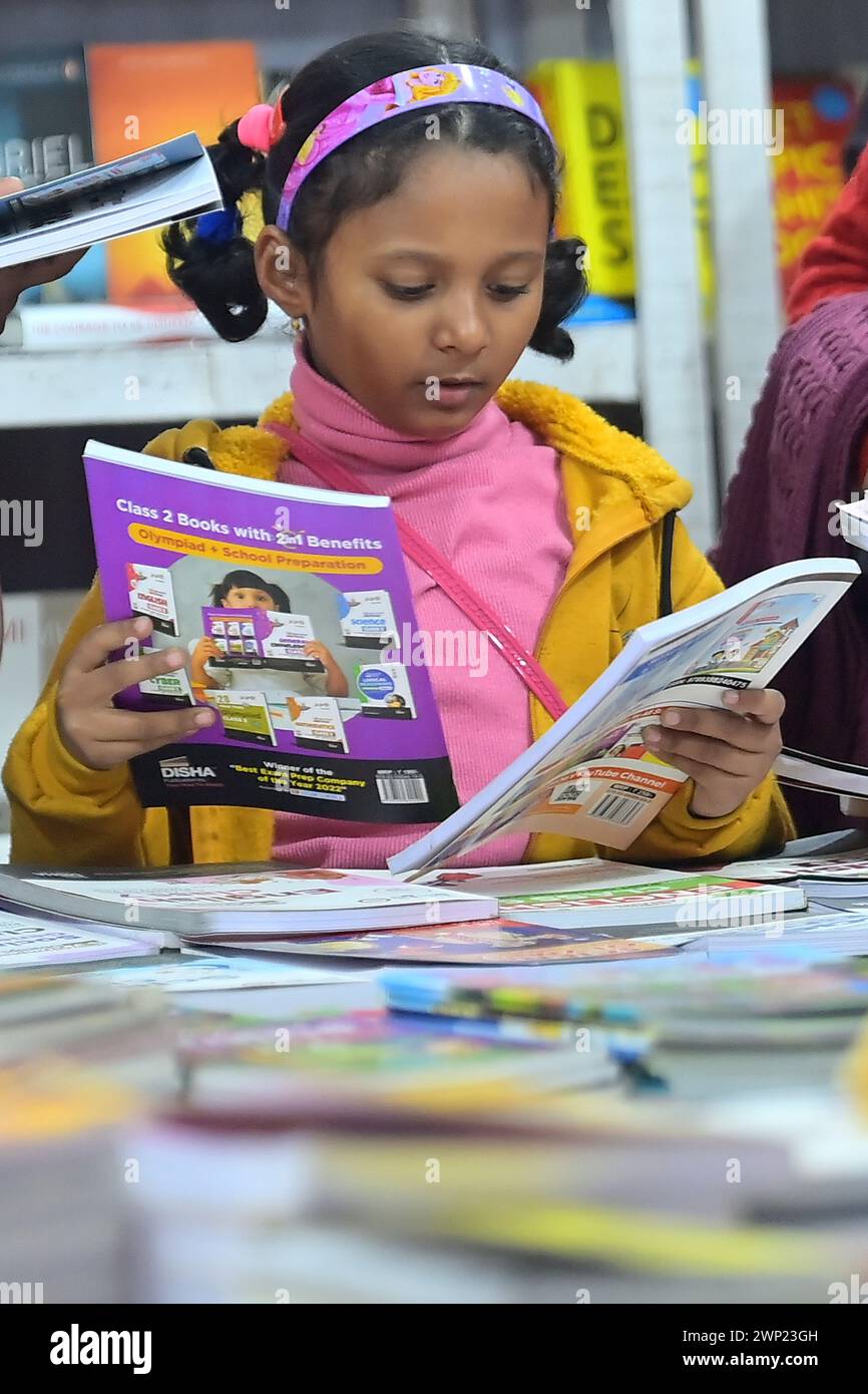 I bambini che guardano i libri in una bancarella di libri al 42° Agartala Book Fair International Fair Ground, Hapania ad Agartala. Tripura, India. Foto Stock