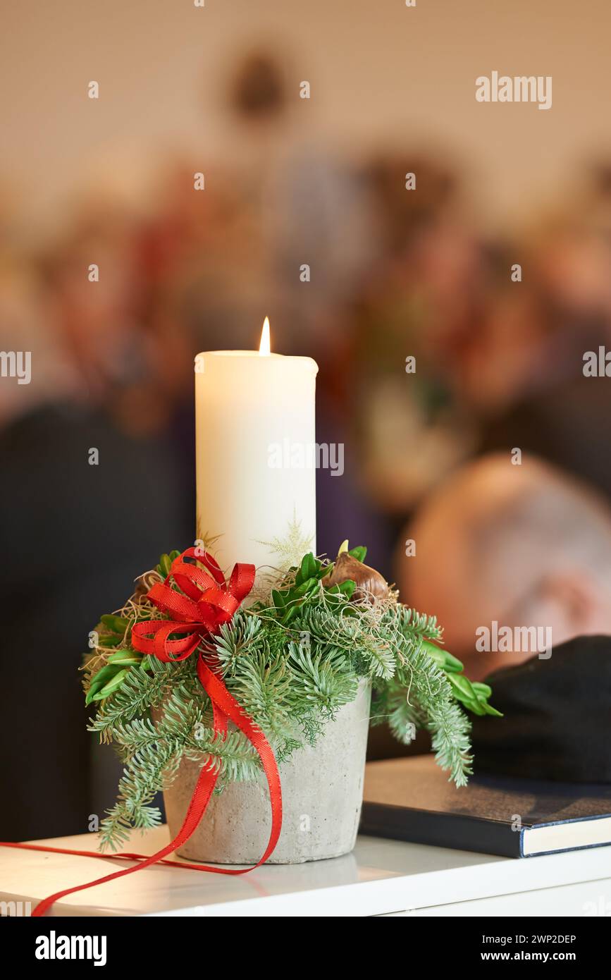 Natale, religione e candela con vischio in chiesa, bibbia e libro sacro o Vangelo in tavola per il culto a Dio. Spirituale, fede e primo piano Foto Stock