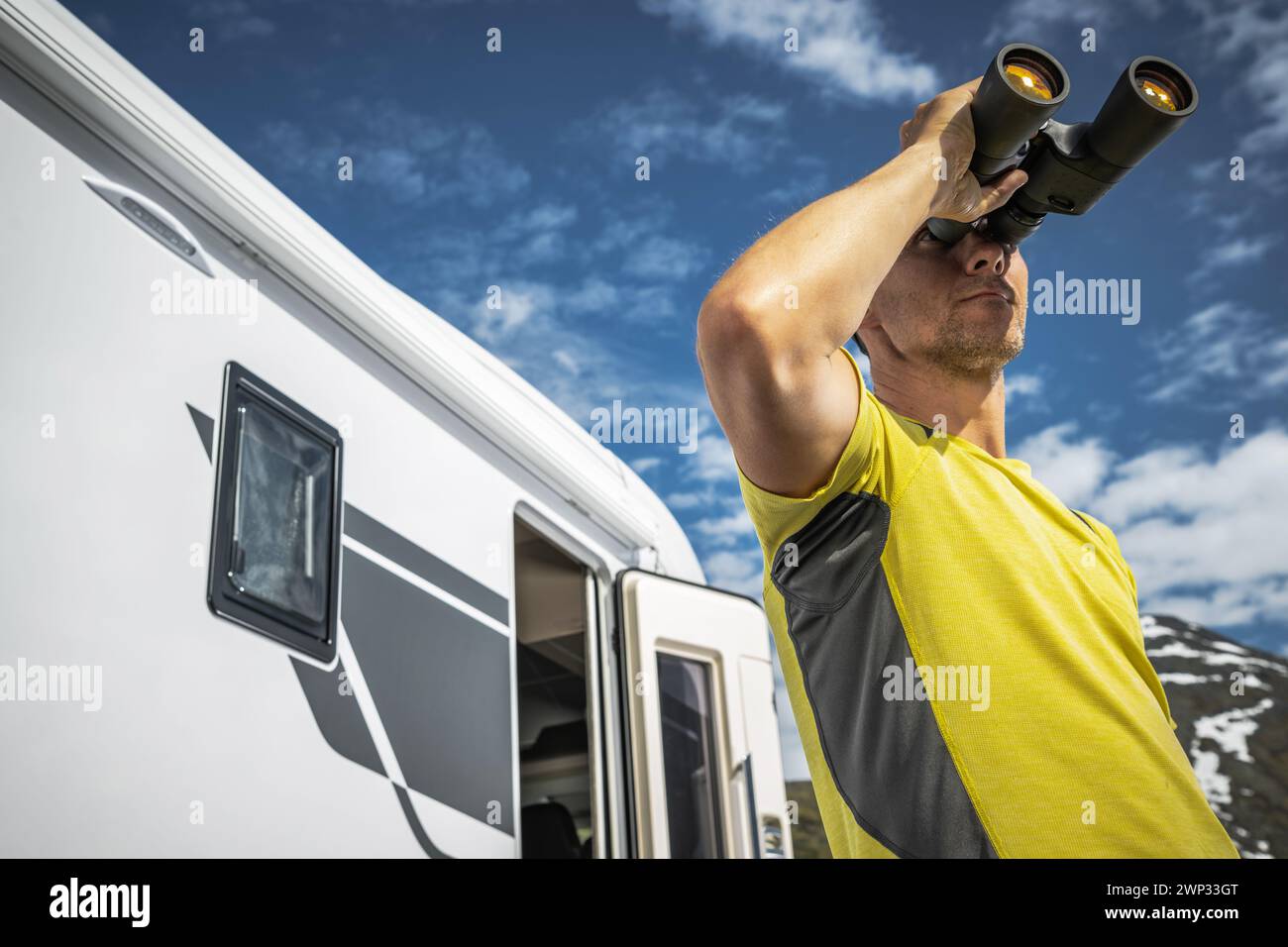 L'uomo caucasico avvista la fauna selvatica con binocoli durante il viaggio in camper in camper Foto Stock