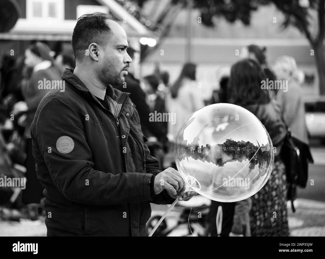 Uomo che soffia bolle al mercatino di natale annuale Foto Stock