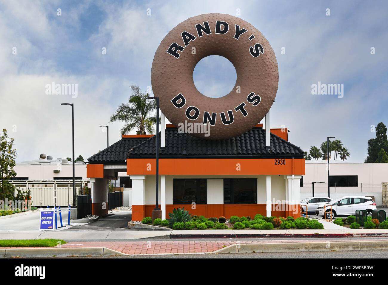 COSTA MESA, CALIFORNIA - 25 FEB 2024: Randys Donuts su Harbor Boulevard, con un'iconica ciambella gigante in cima all'edificio. Foto Stock