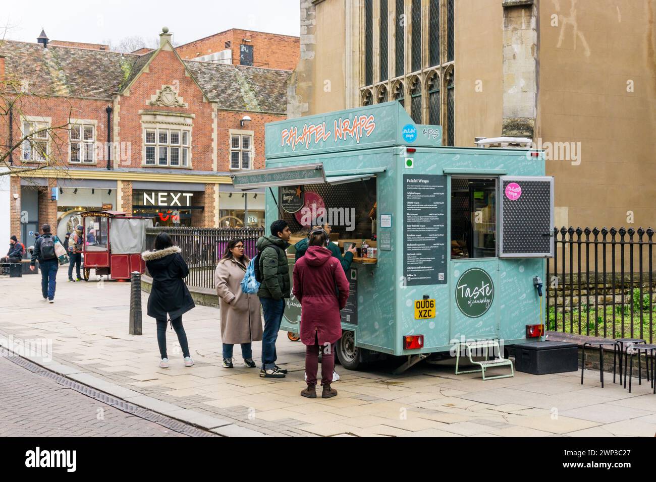 Clienti che fanno la fila in un chiosco alimentare che vende confezioni Falafel a Market Street, Cambridge. Foto Stock