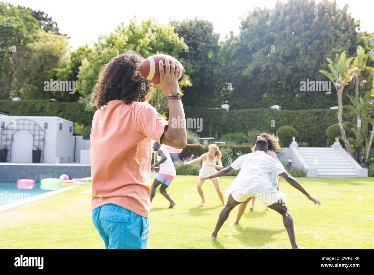 Il giovane afroamericano si prepara a lanciare una partita di football in una partita nel cortile Foto Stock