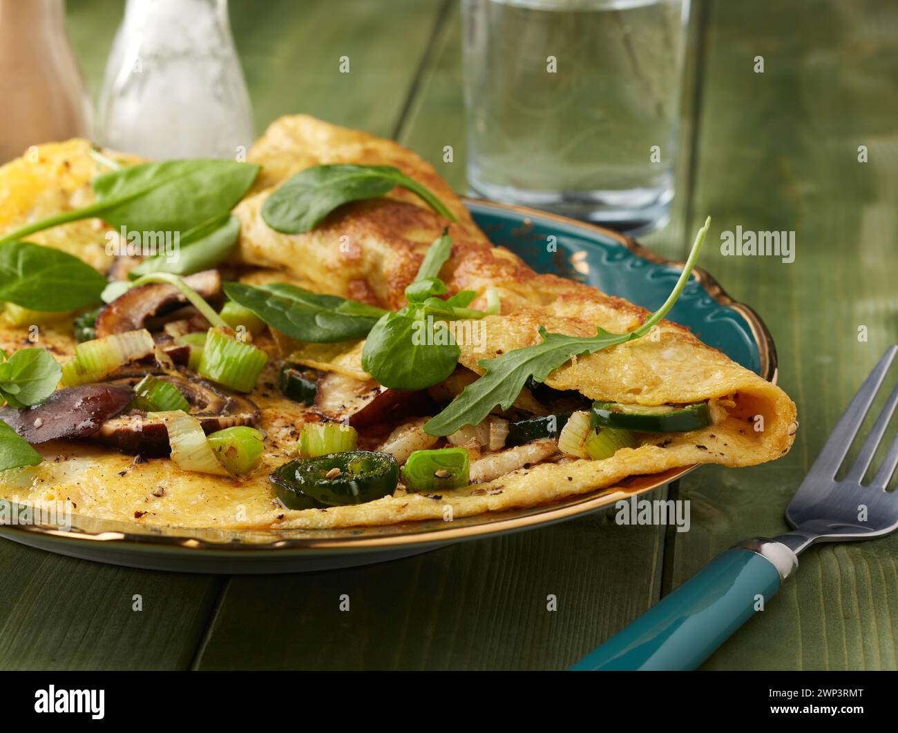 Omelette di funghi piccante guarnita con spinaci e formaggi di parmigiano. Foto Stock