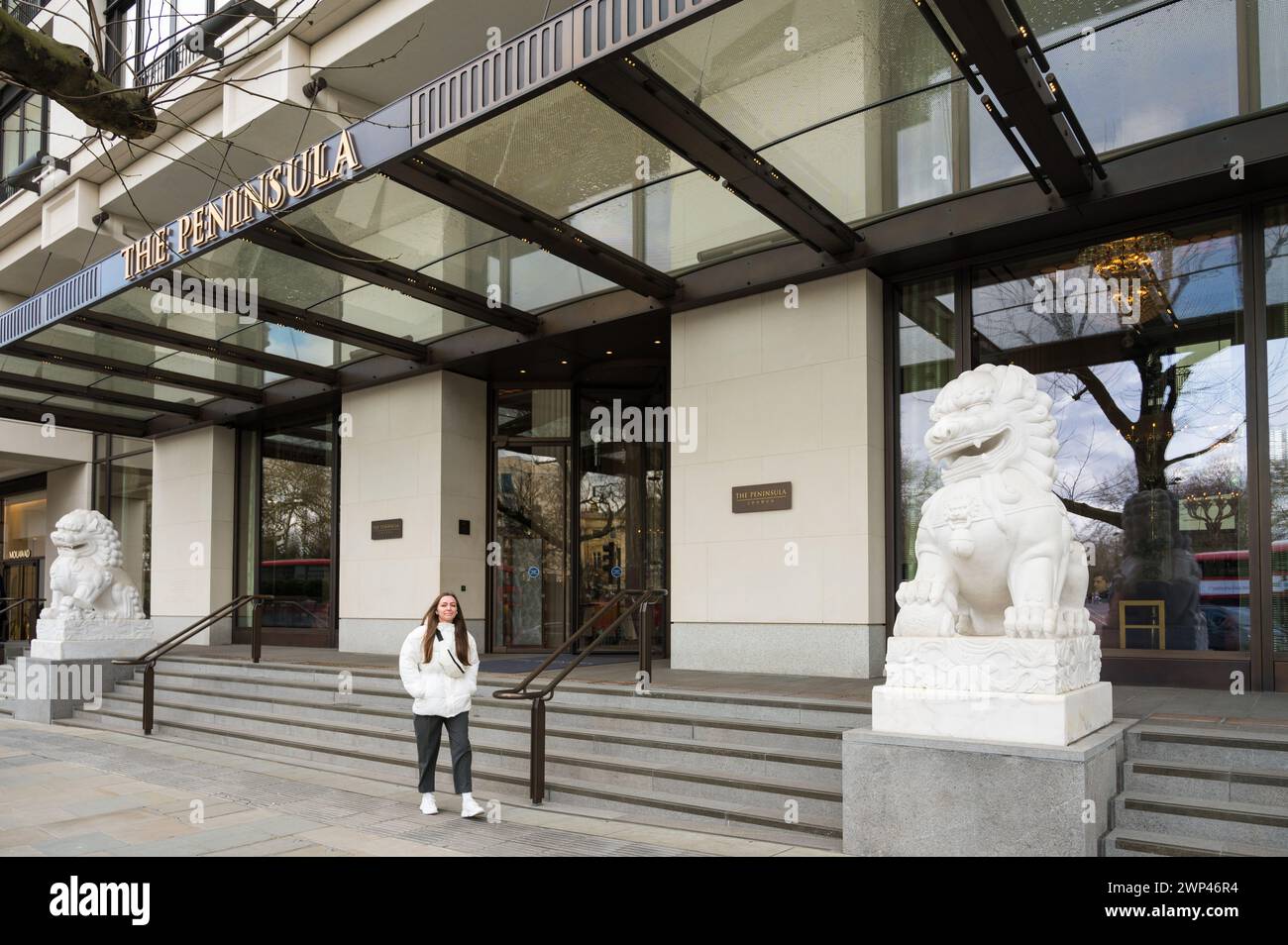 Ingresso principale al Peninsula Hotel a 5 stelle fiancheggiato da statue di leoni guardiani cinesi. Hyde Park Corner Belgravia Londra Inghilterra Regno Unito Foto Stock