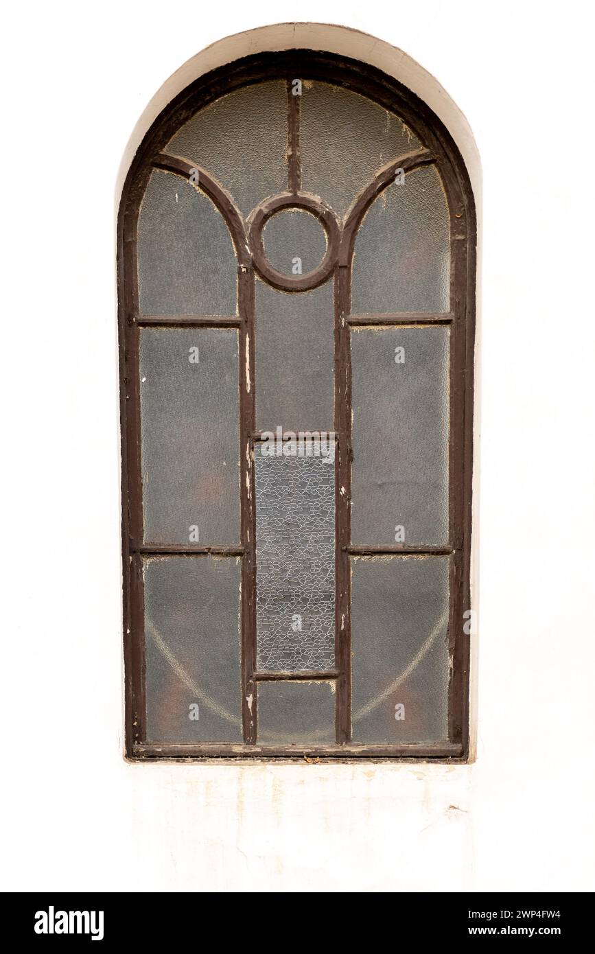 finestra in legno marrone vintage con parete bianca della vecchia chiesa, recinzione metallica e cancello Foto Stock
