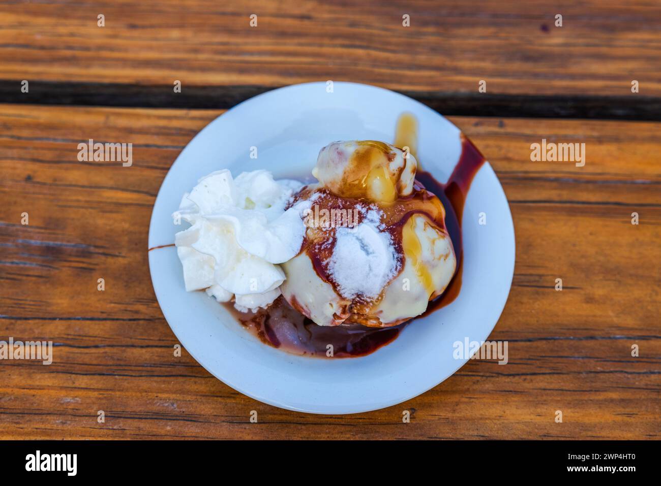 Vista ravvicinata dei vari gusti di gelato su un piatto condito con cioccolato e sciroppo d'arancia. Curacao. Foto Stock