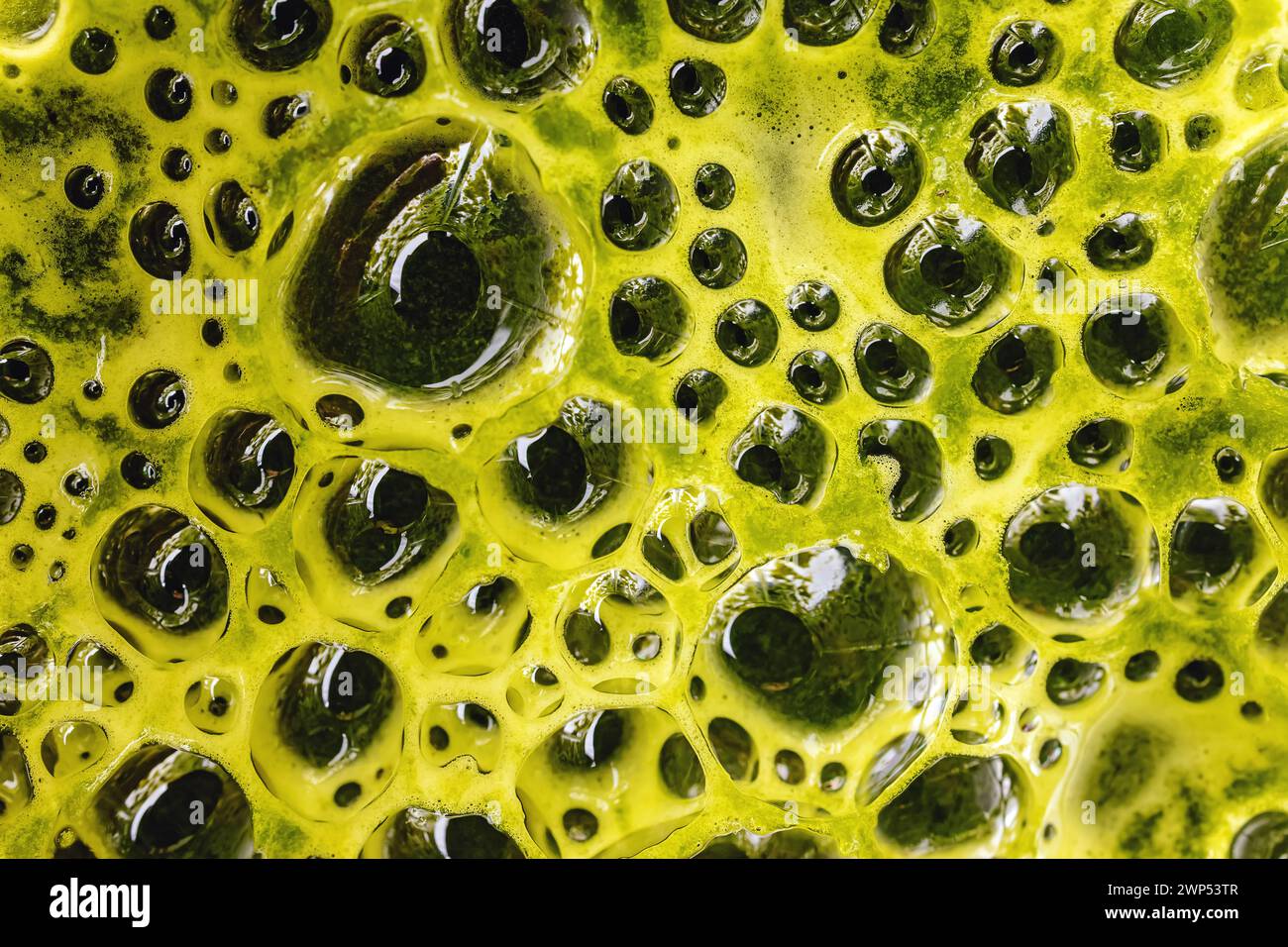 Vista macro della superficie del frullato verde e della bevanda verde miscelata in primo piano Foto Stock