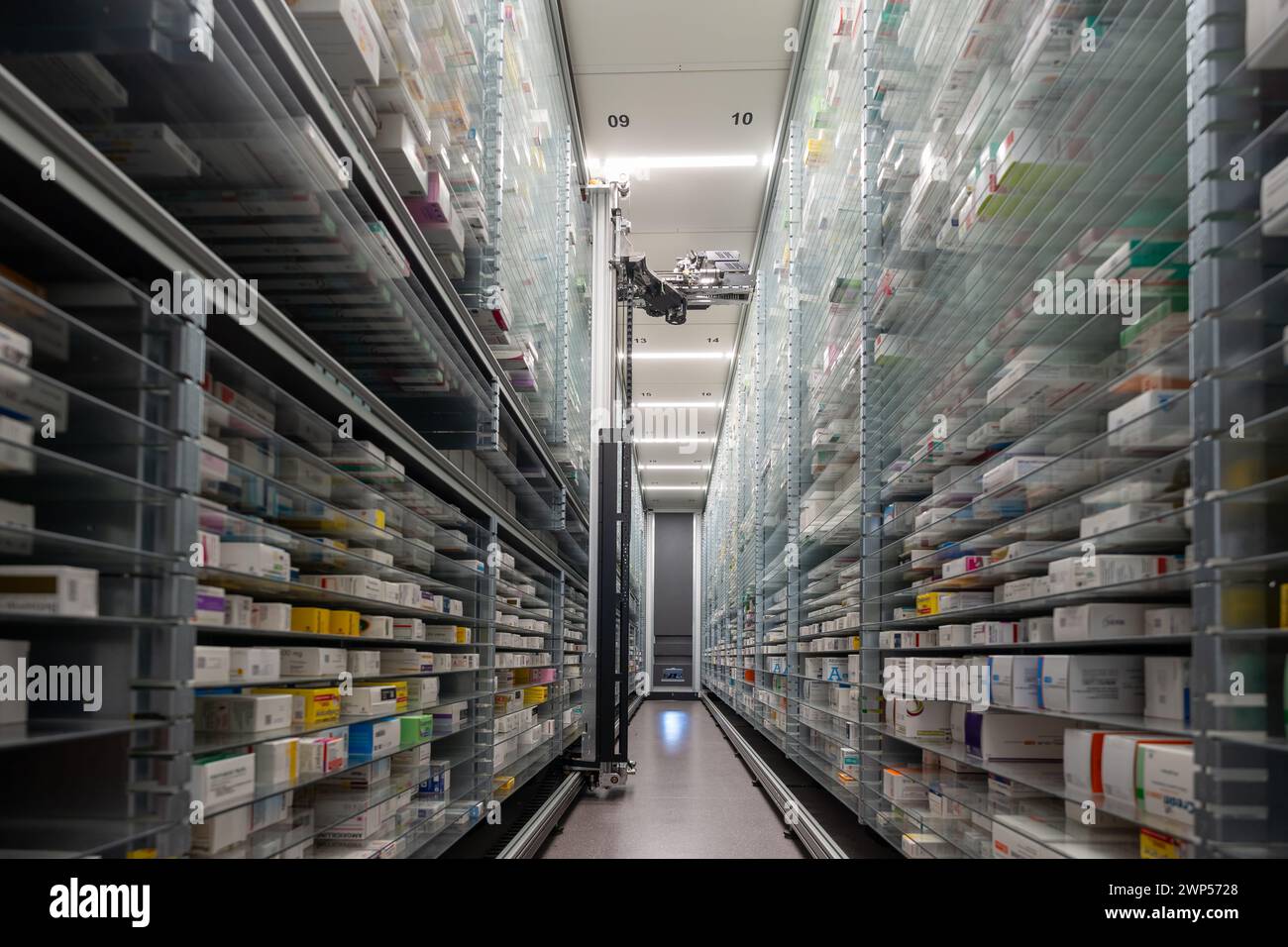 Le fotografie di un magazzino di farmacia e di una mano robot stanno organizzando e conservando farmaci in una farmacia. Foto Stock