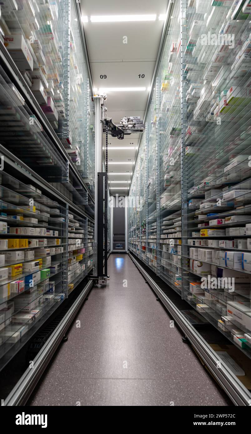 Le fotografie di un magazzino di farmacia e di una mano robot stanno organizzando e conservando farmaci in una farmacia. Foto Stock