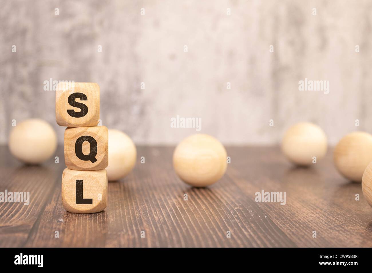 I cubi di legno su sfondo marrone con il testo "SQL" rappresentano il concetto di "Sales Qualified Lead". Visualizza il processo di filtraggio dell'identif Foto Stock