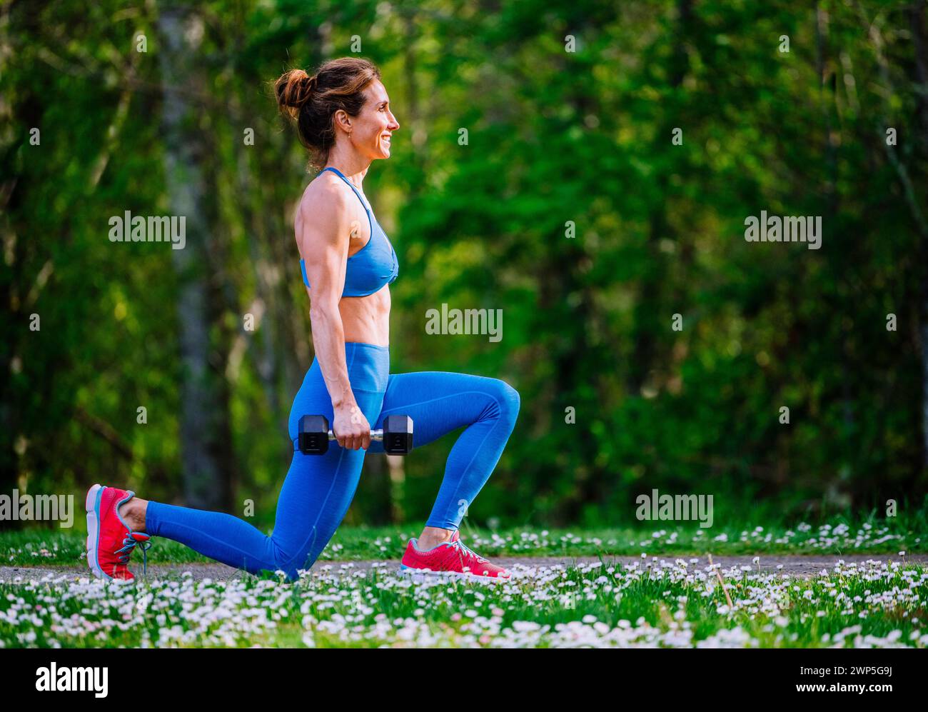 Atleta che si allena indossando abbigliamento sportivo tra i ciliegi Foto Stock