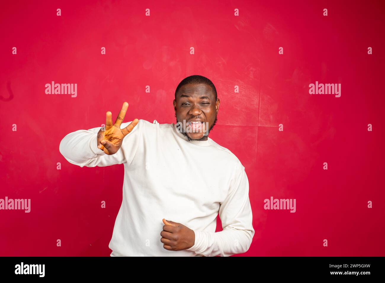 Estremamente felice eccitato giovane afroamericano uomo vincere lotteria scommessa in piedi felici saltando gioiosamente trionfando fidi clench festeggiando il look di successo Foto Stock