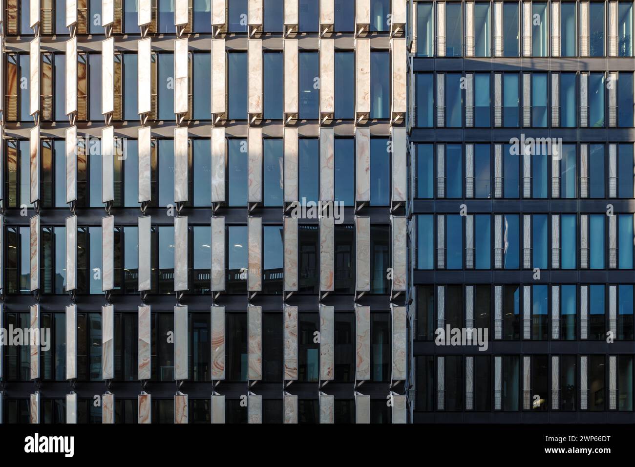 La simmetria geometrica delle facciate dei moderni uffici con un mix di finestre riflettenti in vetro e strutture in metallo. Foto Stock