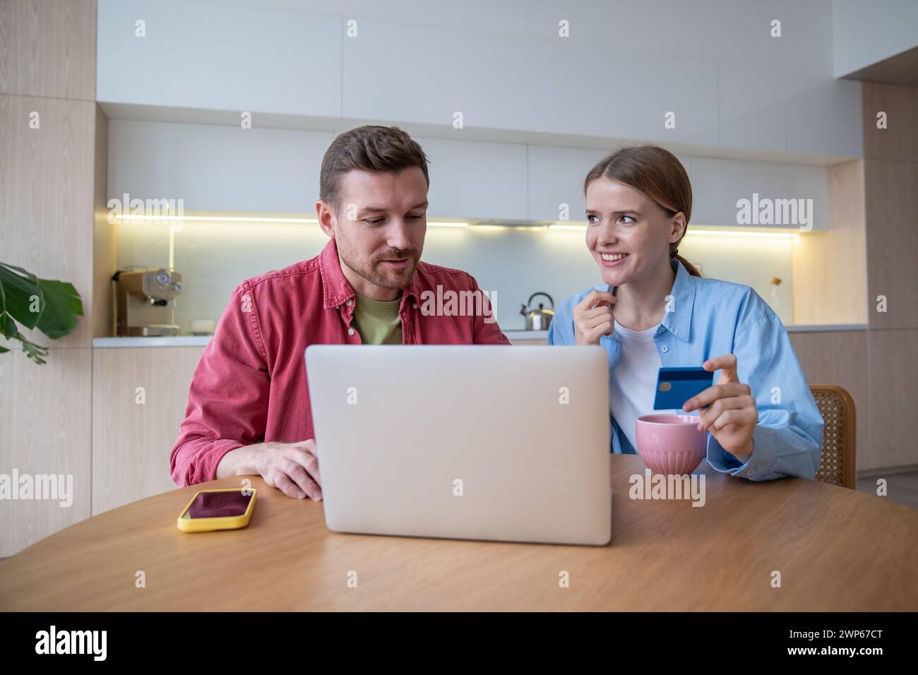 La coppia Millennial fa grandi affari online utilizzando un notebook confortevole a casa. Comodità di shopping online Foto Stock