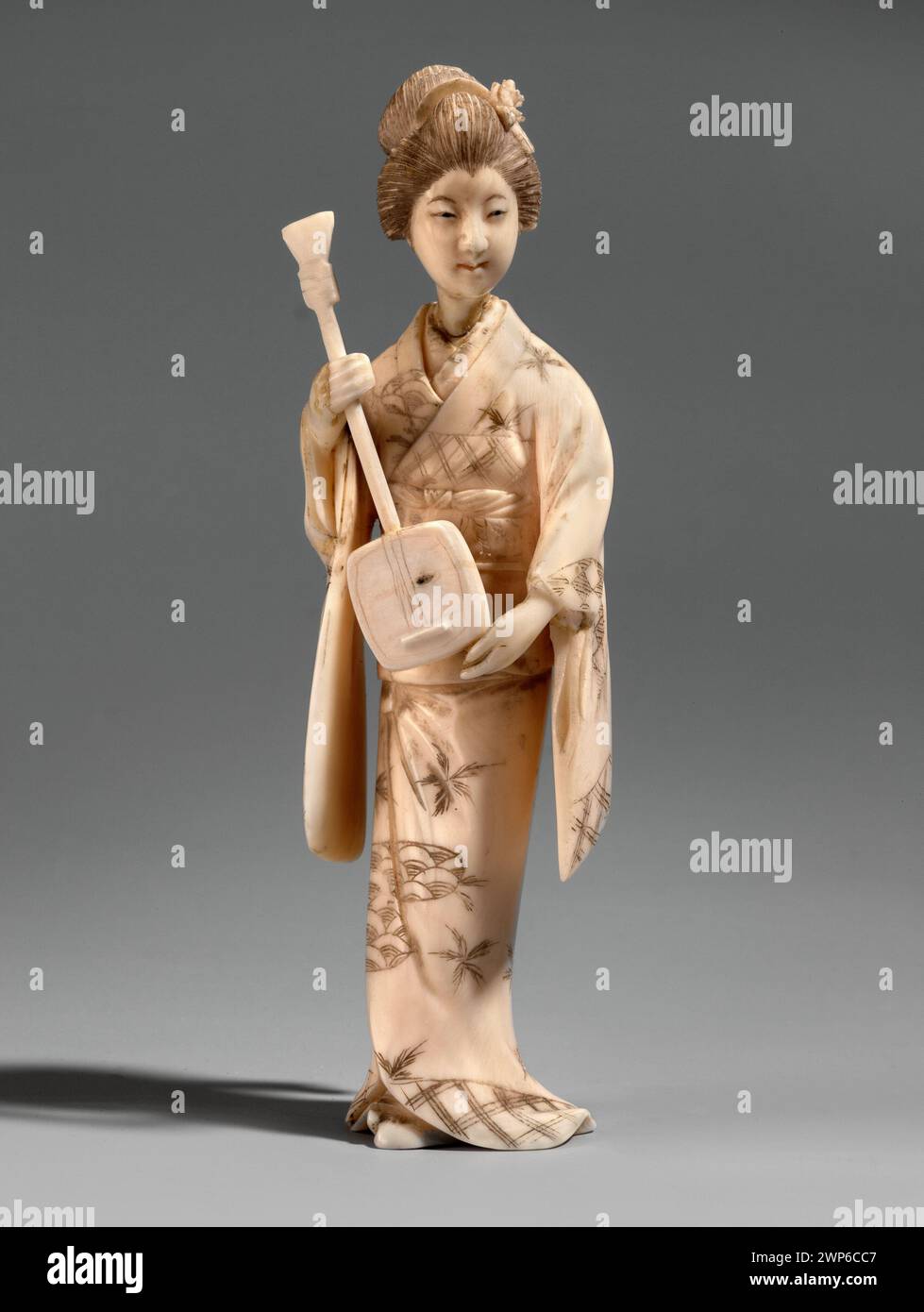 Questo okimono della fine del XIX secolo raffigura una geisha che regge uno shamisen. L'opera fa parte dell'arte giapponese ed era un dono. Foto Stock