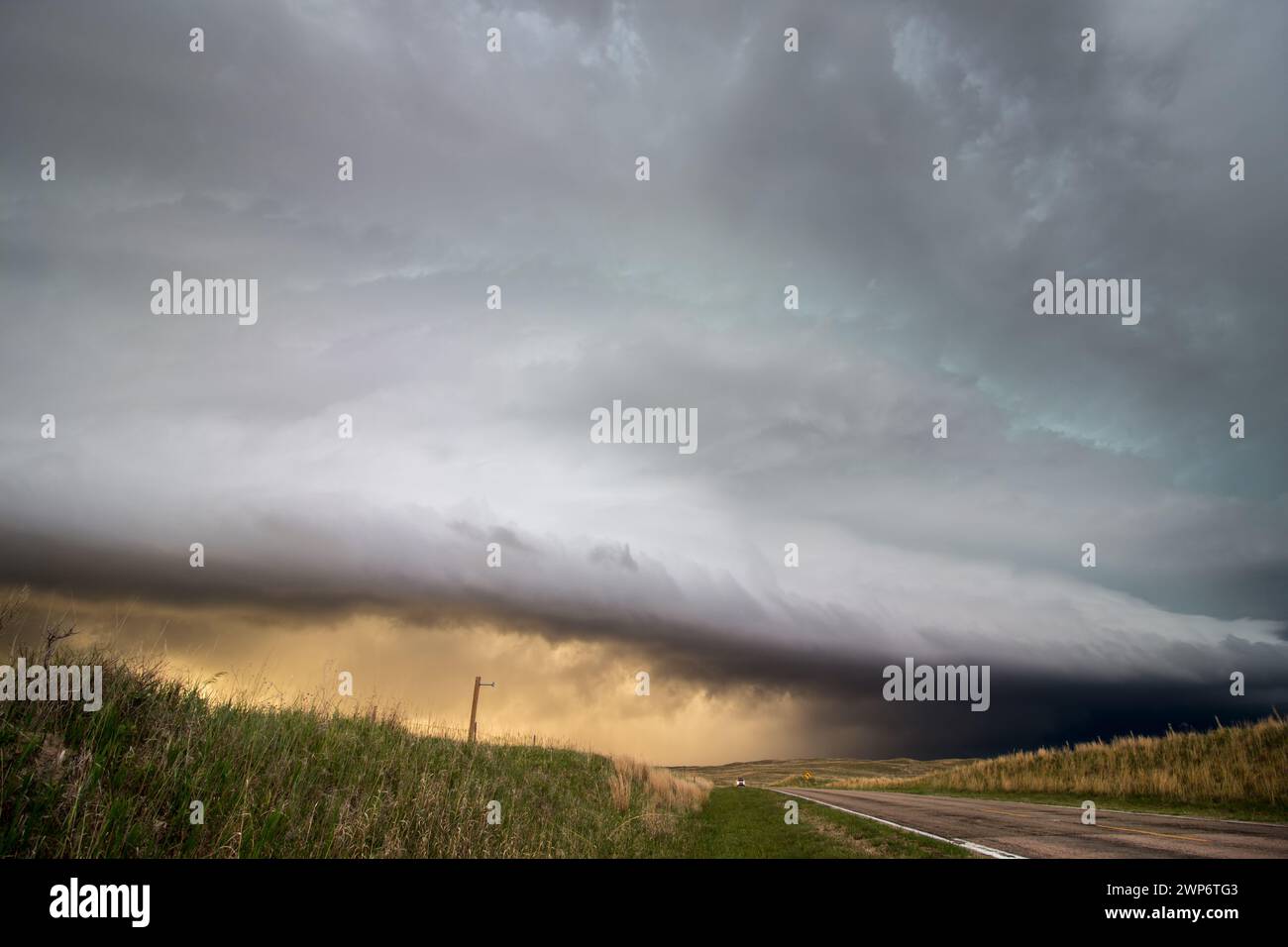 Una nuvola di scaffali incombe su un'autostrada solitaria nelle pianure mentre si avvicina una potente tempesta. Foto Stock