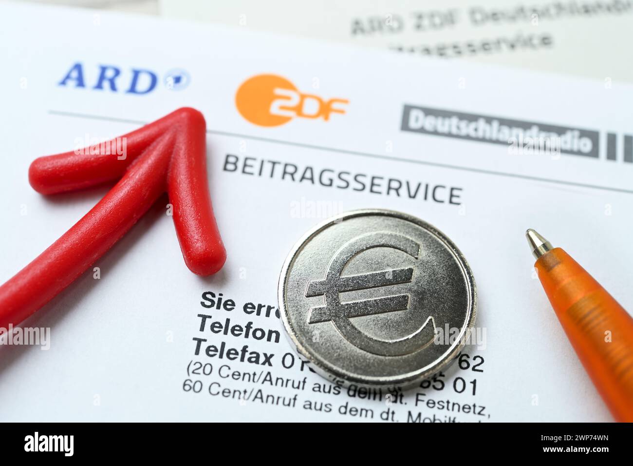 Brief des ARD ZDF Deutschlandradio Beitragsservice mit rotem Pfeil und Münze mit Eurozeichen, Symbolfoto Erhöhung des Rundfunkbeitrags Foto Stock