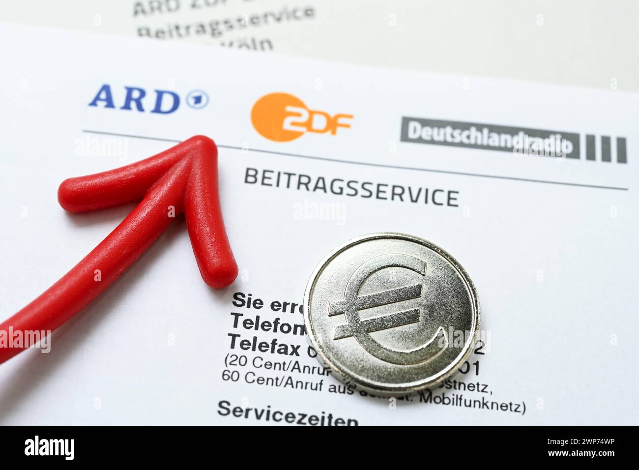 Brief des ARD ZDF Deutschlandradio Beitragsservice mit rotem Pfeil und Münze mit Eurozeichen, Symbolfoto Erhöhung des Rundfunkbeitrags Foto Stock