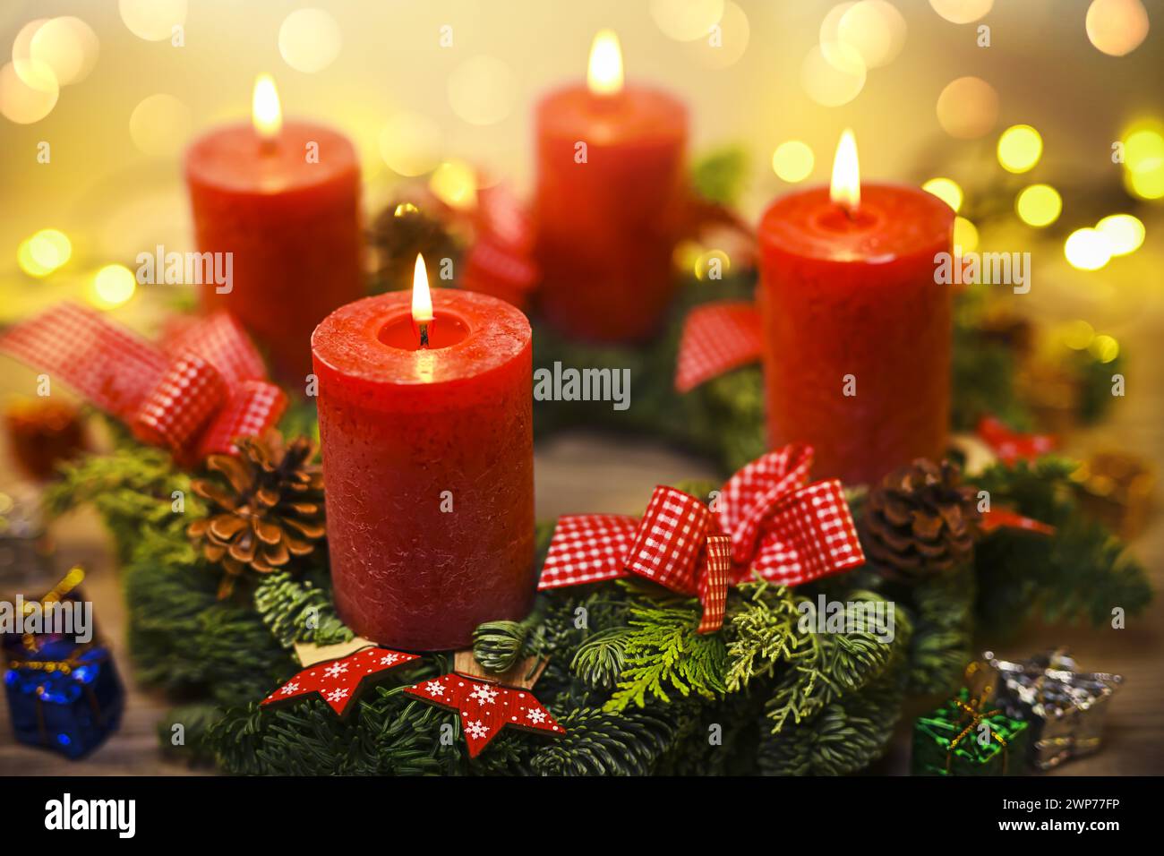 Adventskranz mit vier brennenden Kerzen Foto Stock