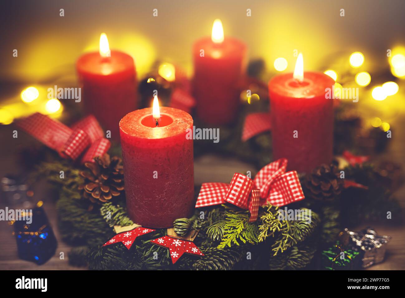 Adventskranz mit vier brennenden Kerzen Foto Stock
