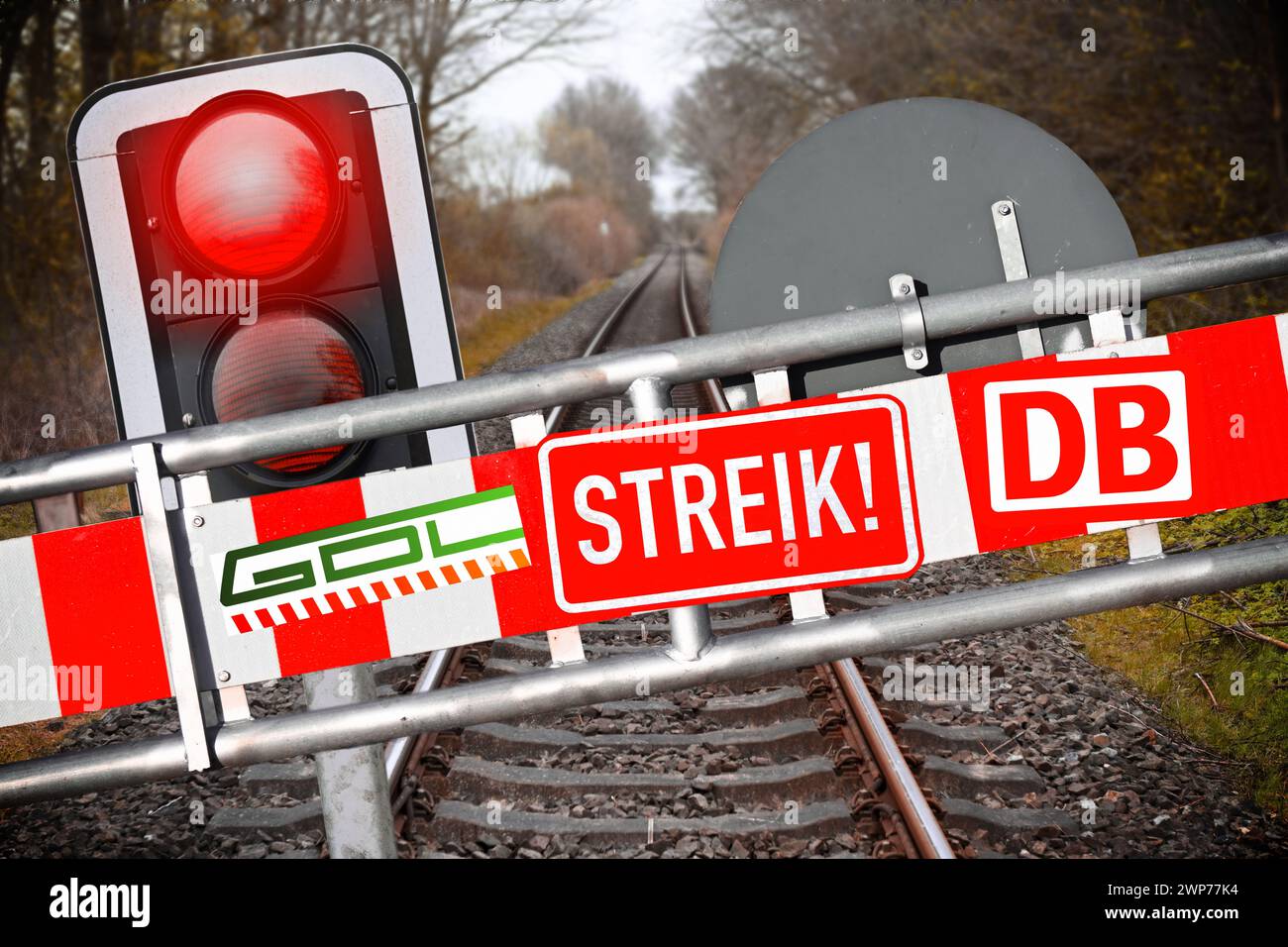 FOTOMONTAGE, Schranke mit Aufschrift Streik, DB und GDL vor leeren Bahnschienen und rotes Haltesignal, Symbolfoto GDL-Streik Foto Stock