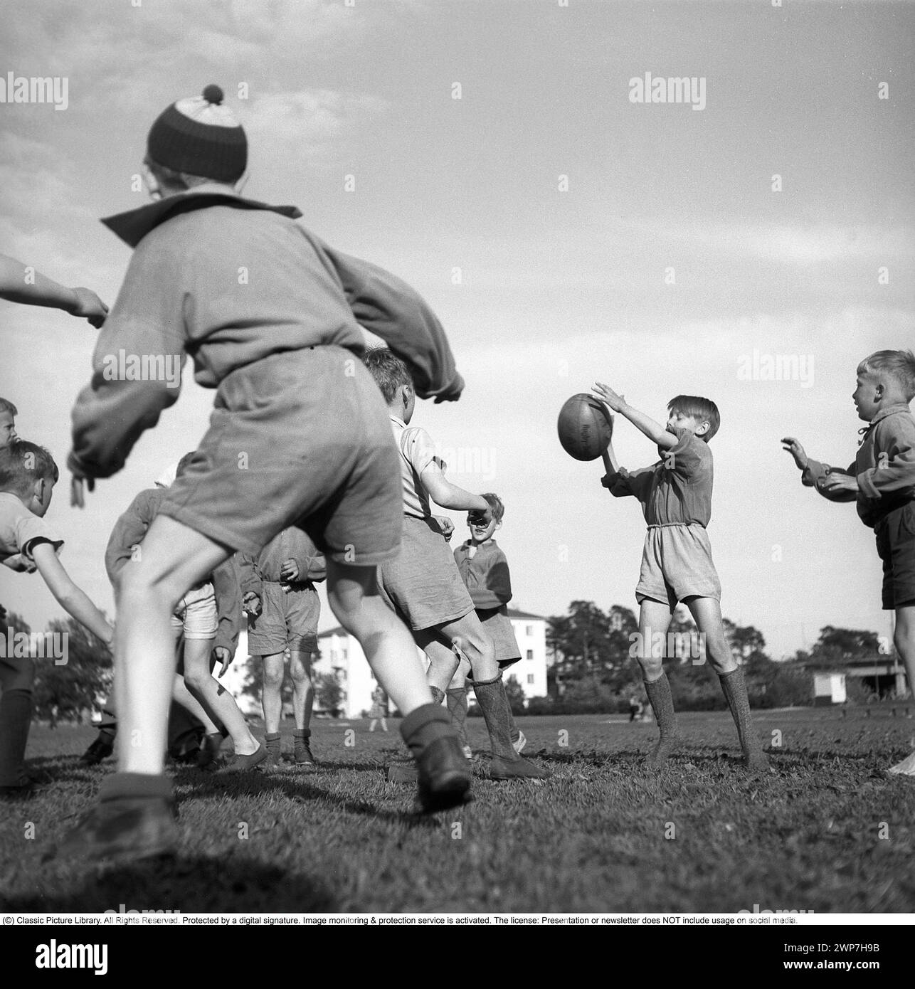 Rugby 1940. I giovani giocatori di rugby praticano insieme. La palla da rugby ha una forma ovale, quattro pannelli e un peso di circa 400 grammi. 1942. Kristoffersson rif. A55-2 Foto Stock