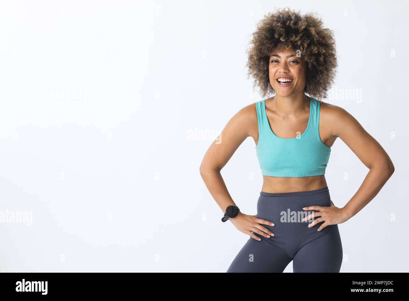 Giovane donna birazziale in abbigliamento da allenamento sorride con fiducia con spazio copia Foto Stock