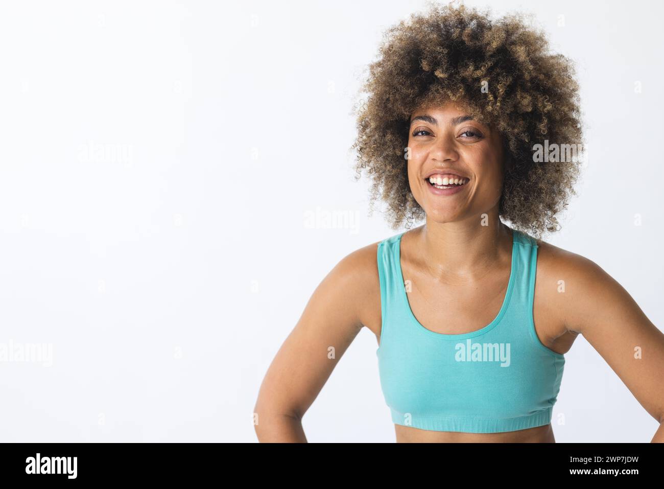 La giovane donna birazziale sorride brillantemente in un ambiente fitness con spazio fotocopie Foto Stock