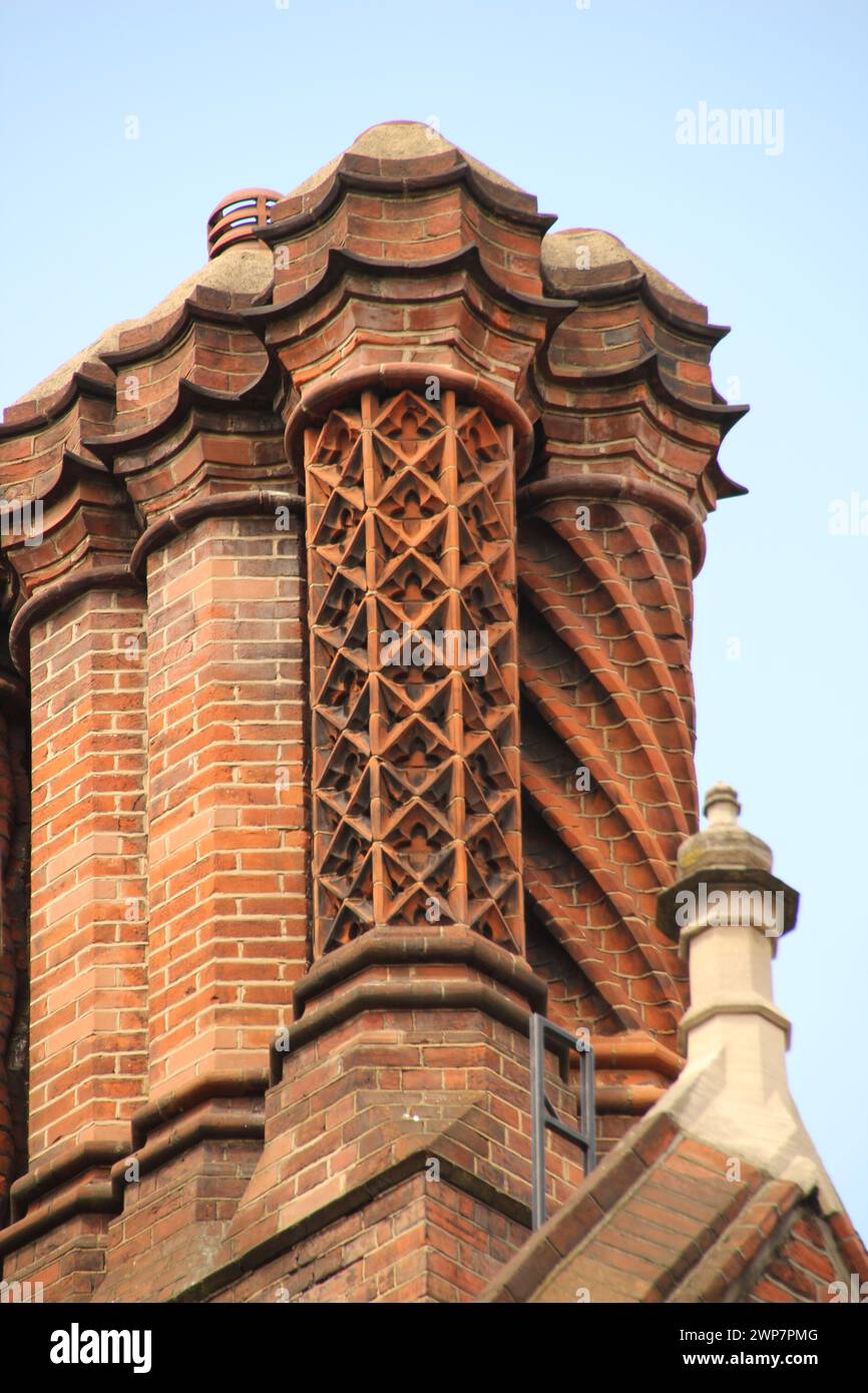 Un edificio in mattoni rossi con intricati ornamenti metallici sul tetto a Londra Foto Stock