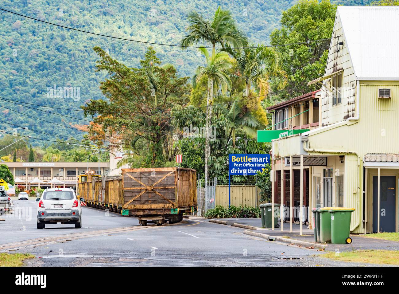 Due locomotive ferroviarie per la canna da zucchero di nome Douglas e Faughy che tirano i bidoni della mulino per la canna da zucchero attraverso la città di Mossman nel Queensland, Australia Foto Stock