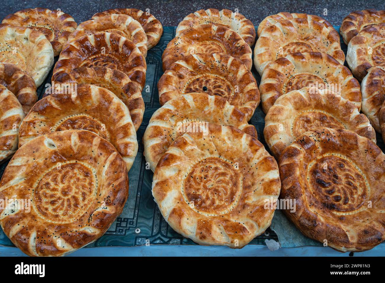 Vista ravvicinata del delizioso pane fresco tradizionale conosciuto come non aka naan o lepeshka su una bancarella del mercato, Khujand, Tagikistan Foto Stock