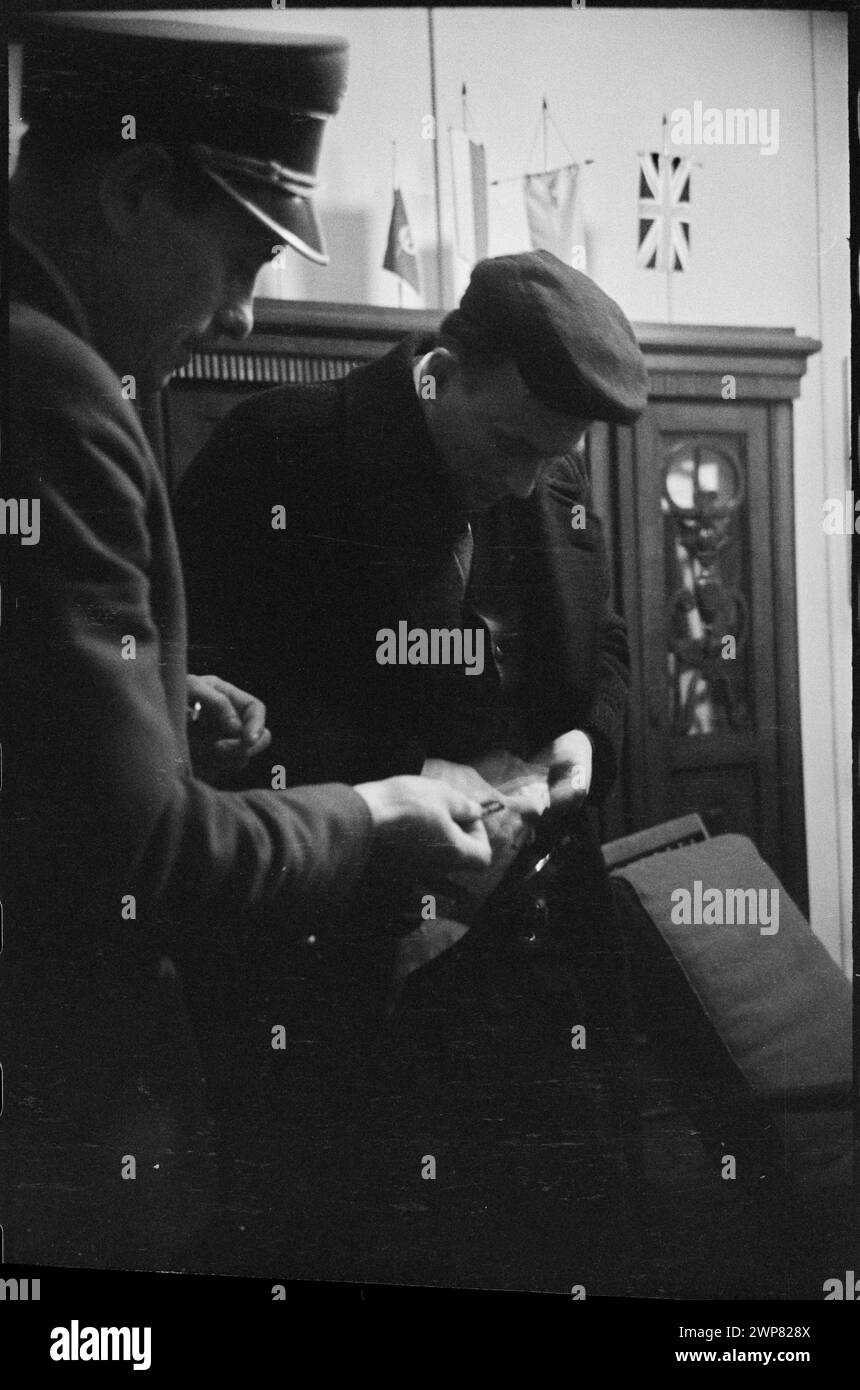 Foto del 1959 che mostra il controllo del passaporto e dei bagagli presso la stazione estera dell'aeroporto di Varsavia, con un funzionario doganale che informa un viaggiatore. L'immagine documenta le procedure di sicurezza dell'aeroporto. Foto Stock