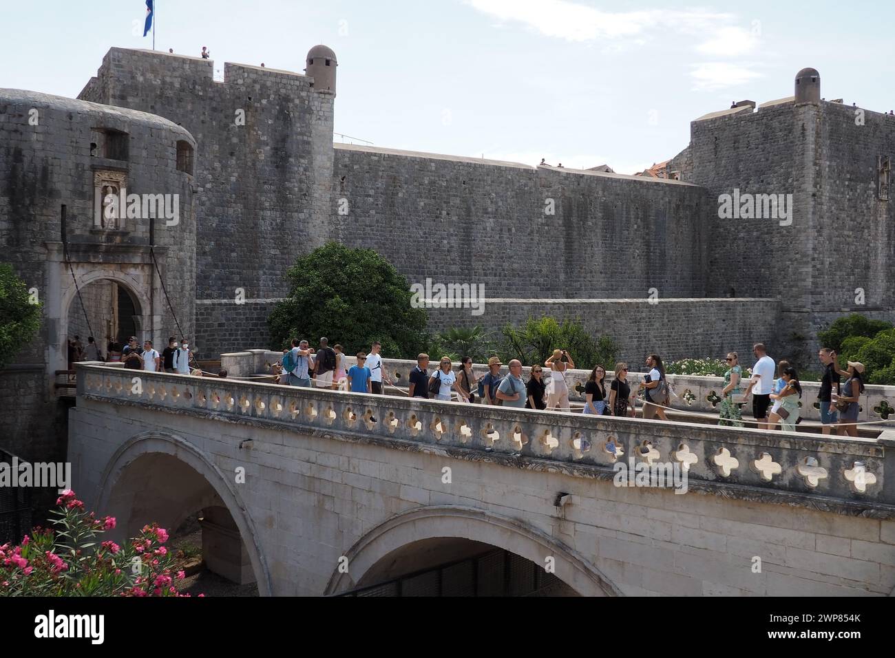 Pile Gate Dubrovnik Croazia 14 agosto 2022 persone uomini e donne camminano lungo il ponte di pietra fino al cancello della città Vecchia. Una folla di turisti. Occupato Foto Stock