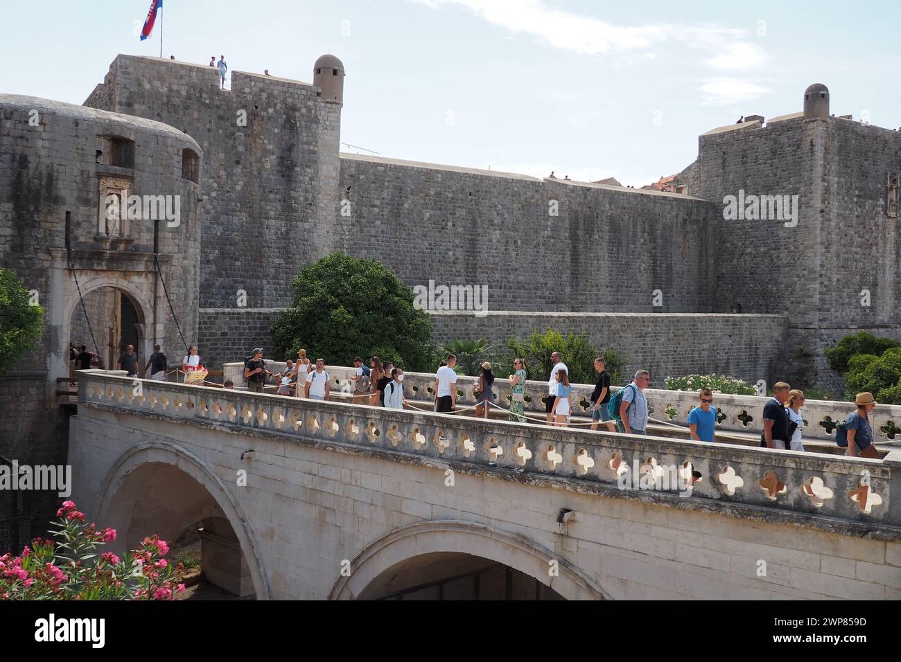 Pile Gate Dubrovnik Croazia 14 agosto 2022 persone uomini e donne camminano lungo il ponte di pietra fino al cancello della città Vecchia. Una folla di turisti. Occupato Foto Stock