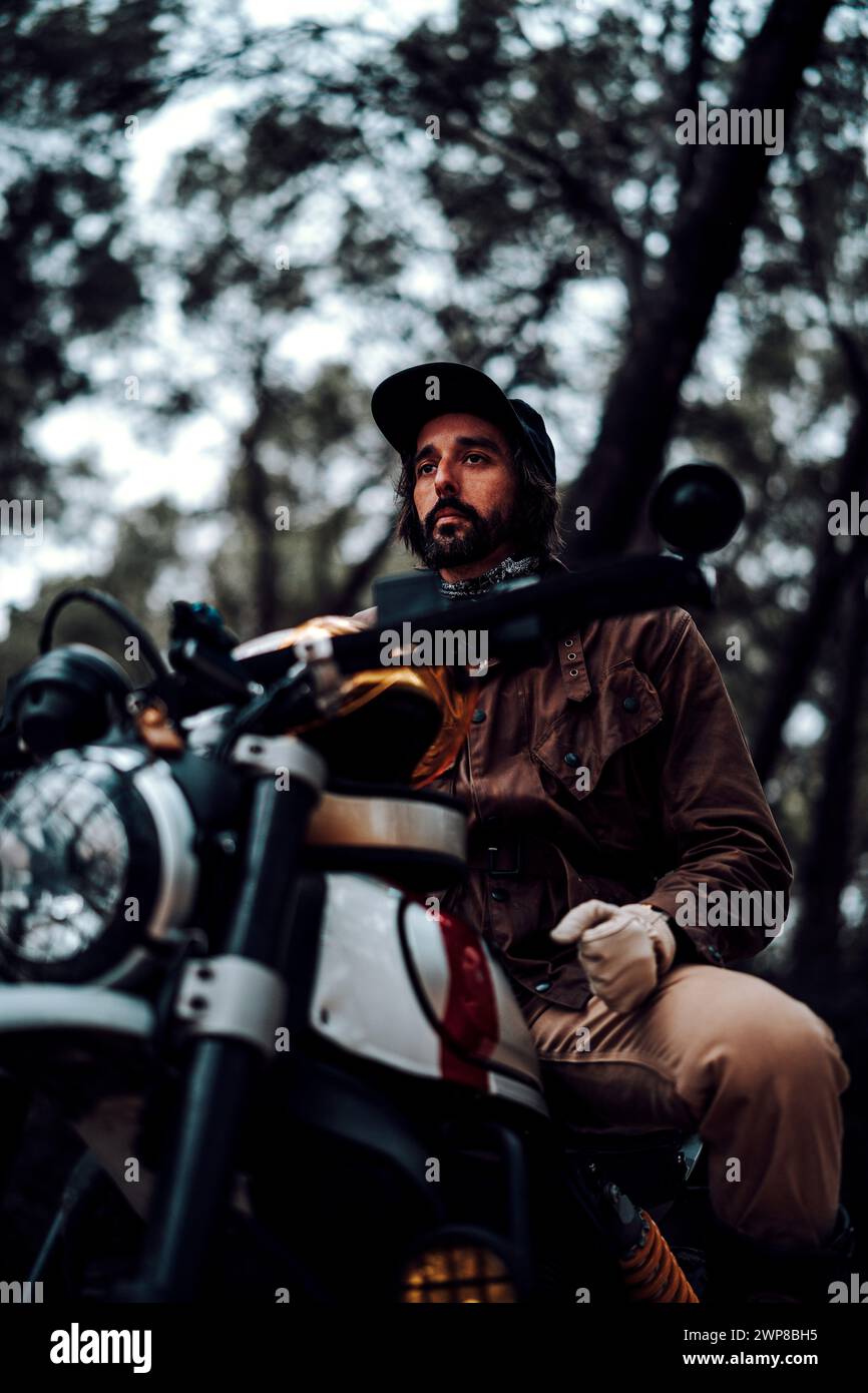 Un colpo verticale ad angolo basso di un uomo seduto su una moto Foto Stock