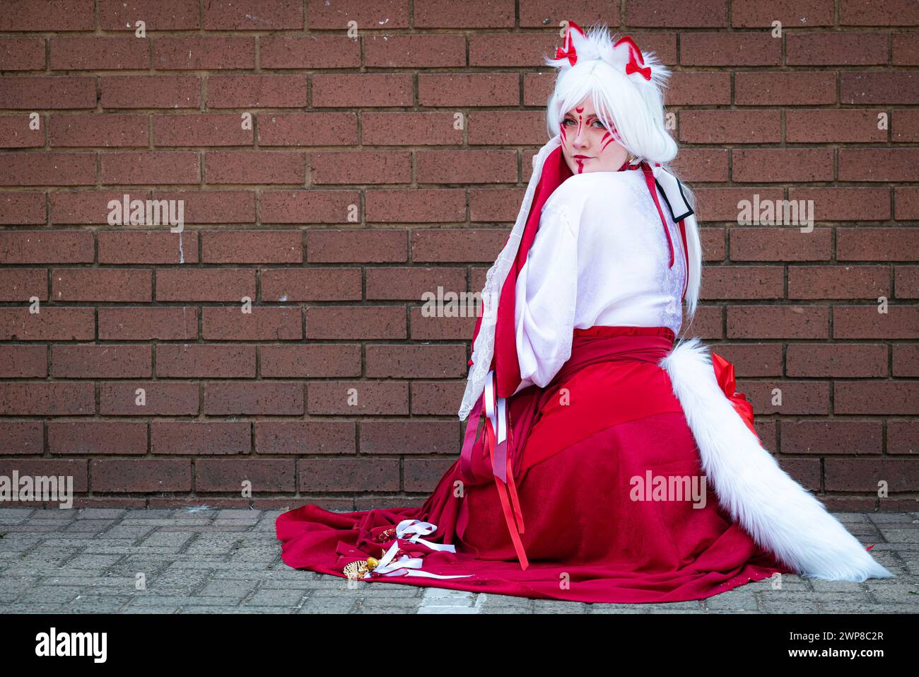 Cosplayer donna in abbigliamento da sacerdotessa felina ad una convention Foto Stock