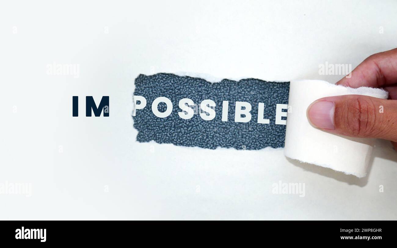 La carta strappata separa le parole impossibile da possibile Foto Stock