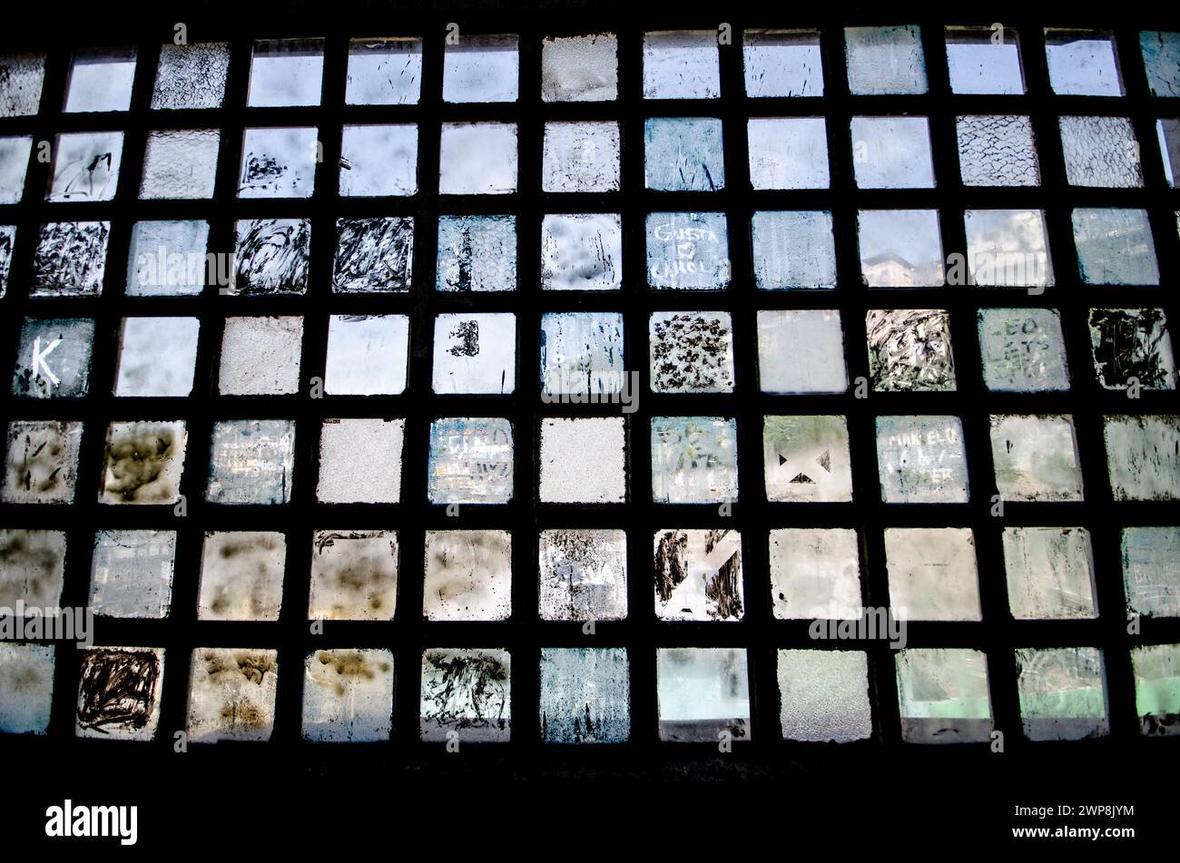 Le finestre sporche all'interno di un edificio industriale abbandonato Foto Stock