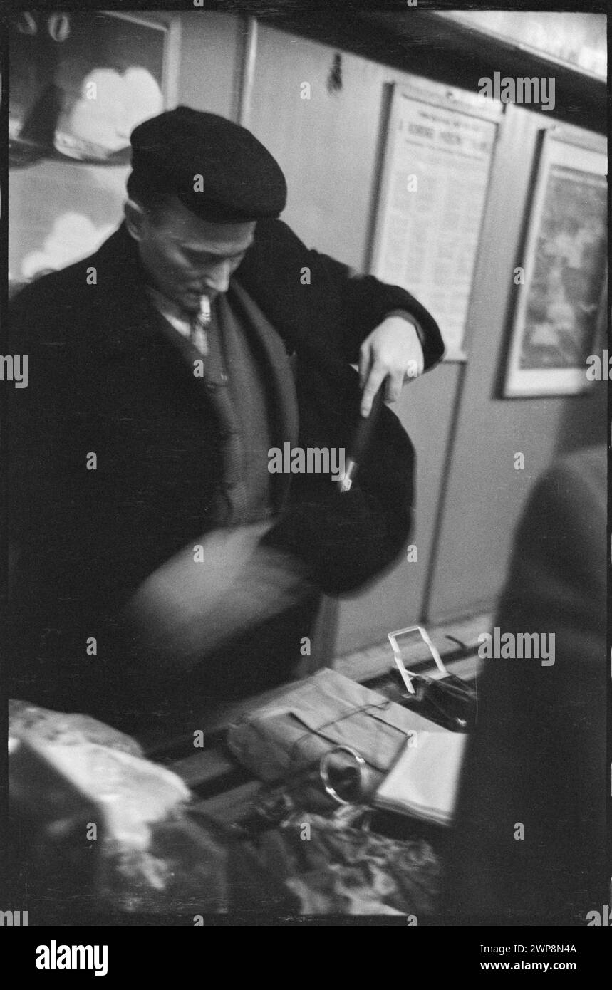 Una fotografia in bianco e nero del 1959 che mostra un viaggiatore sotto controllo bagagli alla stazione estera dell'aeroporto di Varsavia. L'immagine raffigura un controllo del passaporto e un briefing da parte del personale doganale nell'ambito delle procedure aeroportuali standard. Foto Stock