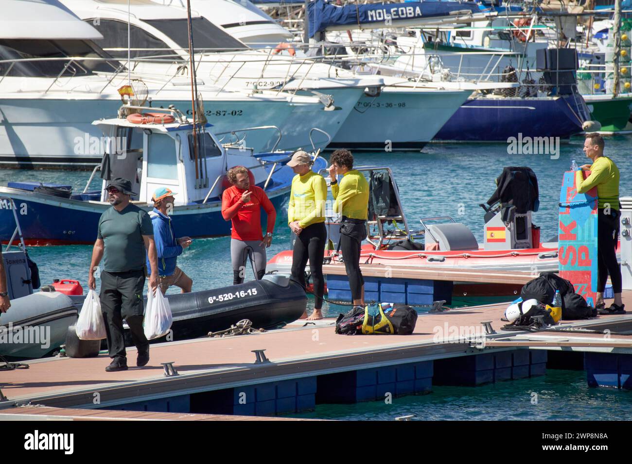 Kitesurfer e gommoni che parlano sul pontile nel porto turistico di corralejo dopo un viaggio fuori Fuerteventura, Isole Canarie, spagna Foto Stock