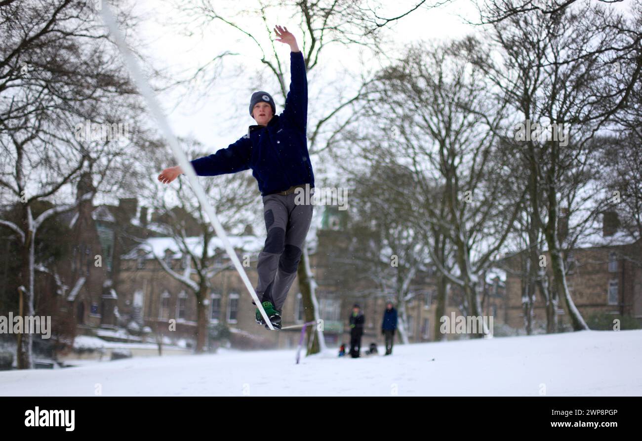 05/02/13 Matt Stevens, 19 anni, pratica slacklining lungo una linea tra gli alberi di Buxton, Derbyshire, durante le forti nevicate. La neve dà una S. Foto Stock