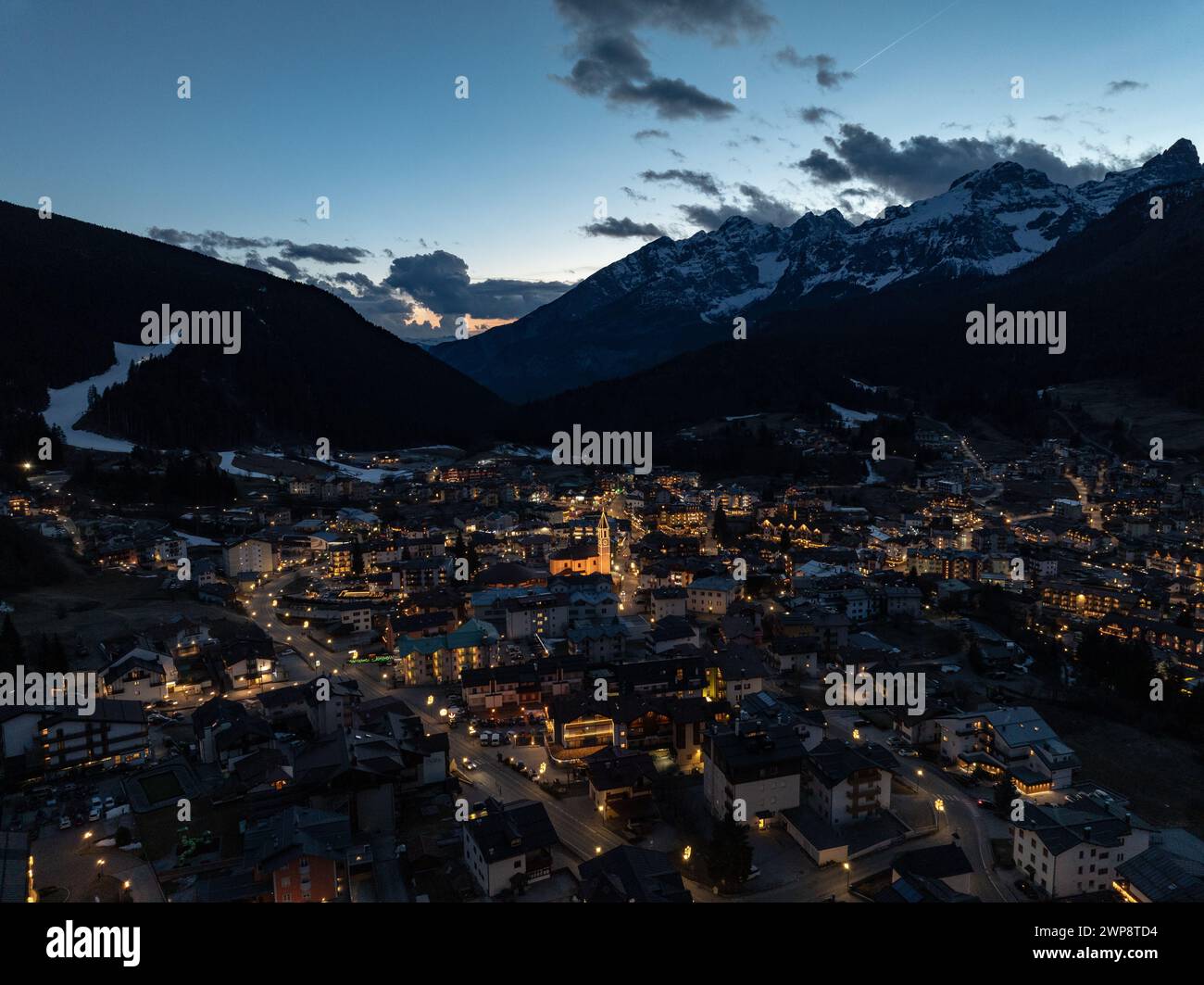 Vista aerea notturna della città di Andalo con droni e montagne sullo sfondo in inverno. Località sciistica Paganella Andalo, Trentino-alto Adige, Italia Foto Stock