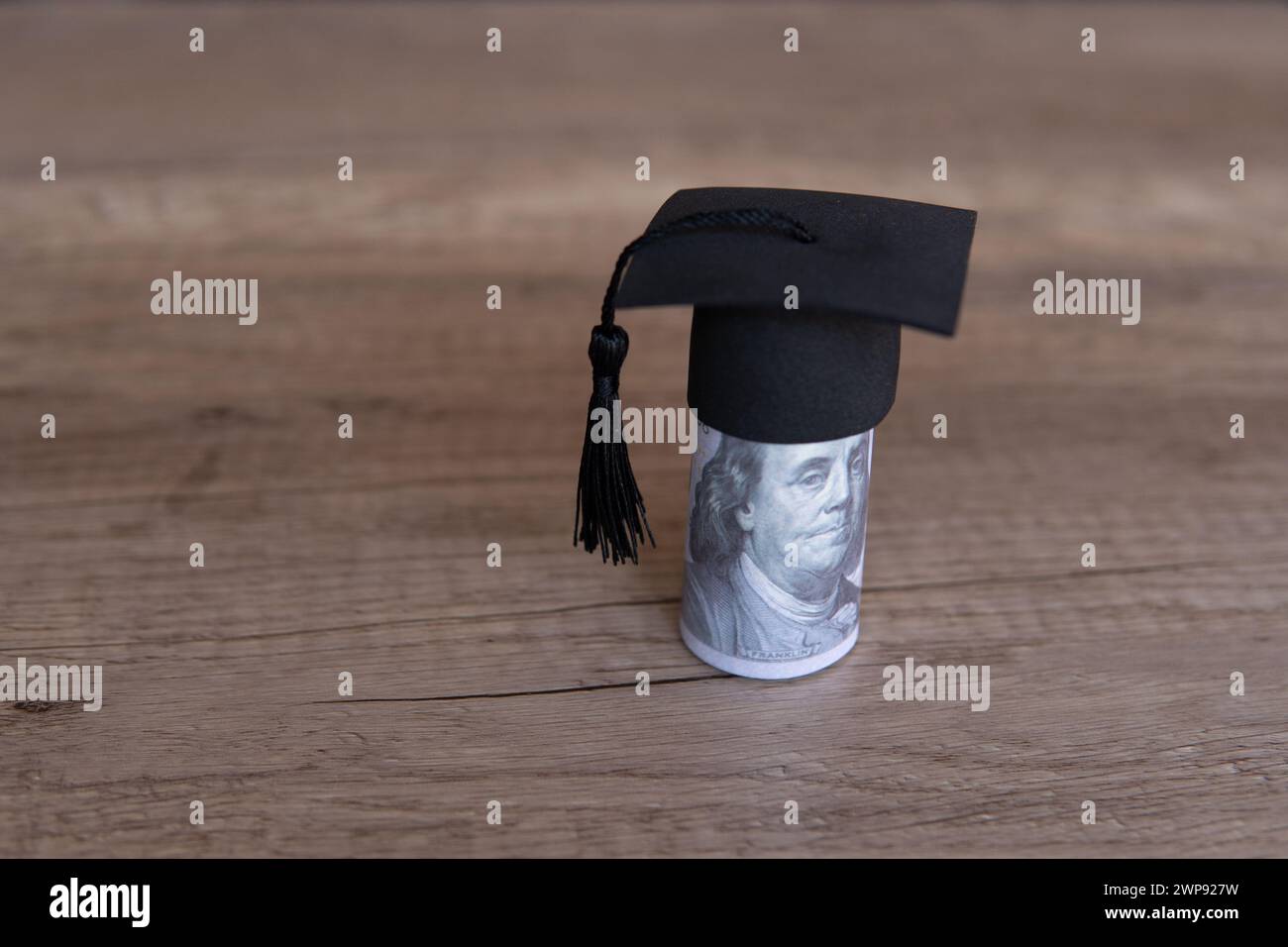 Immagine ravvicinata del cappello di graduazione e dei soldi sul tavolo. Borsa di studio, concetto di tasse educative. Copia spazio per il testo. Foto Stock