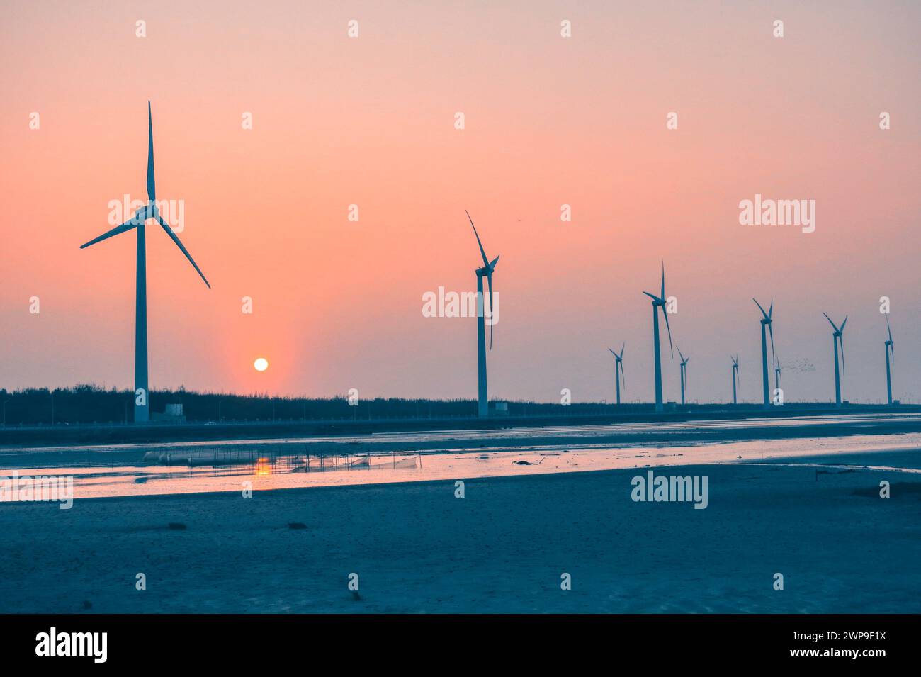 Le turbine eoliche in un campo al tramonto, il paesaggio delle fonti di energia rinnovabile Foto Stock