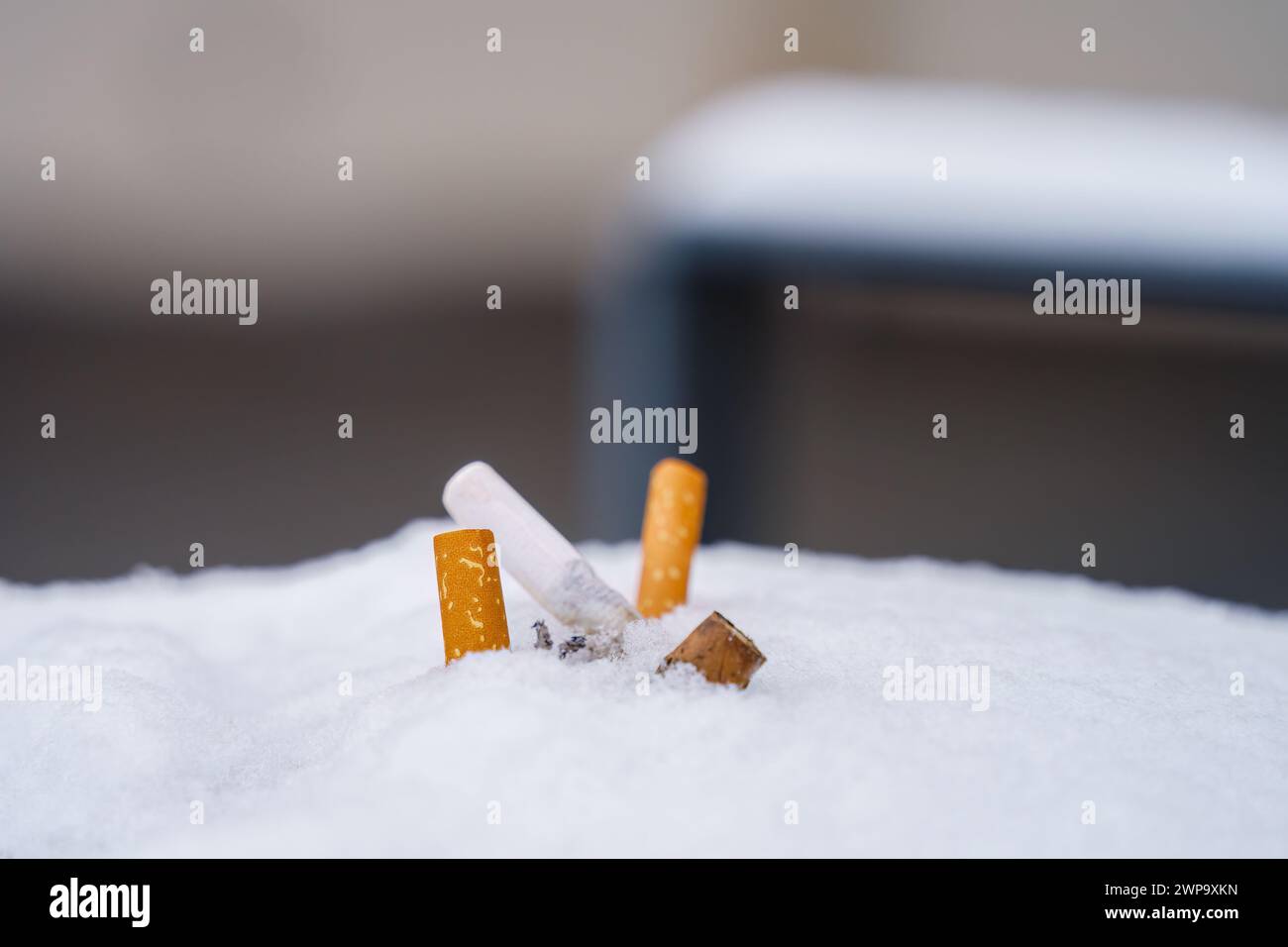 Vista ravvicinata di una pila di mozziconi di sigaretta gettati sulla neve. Foto Stock