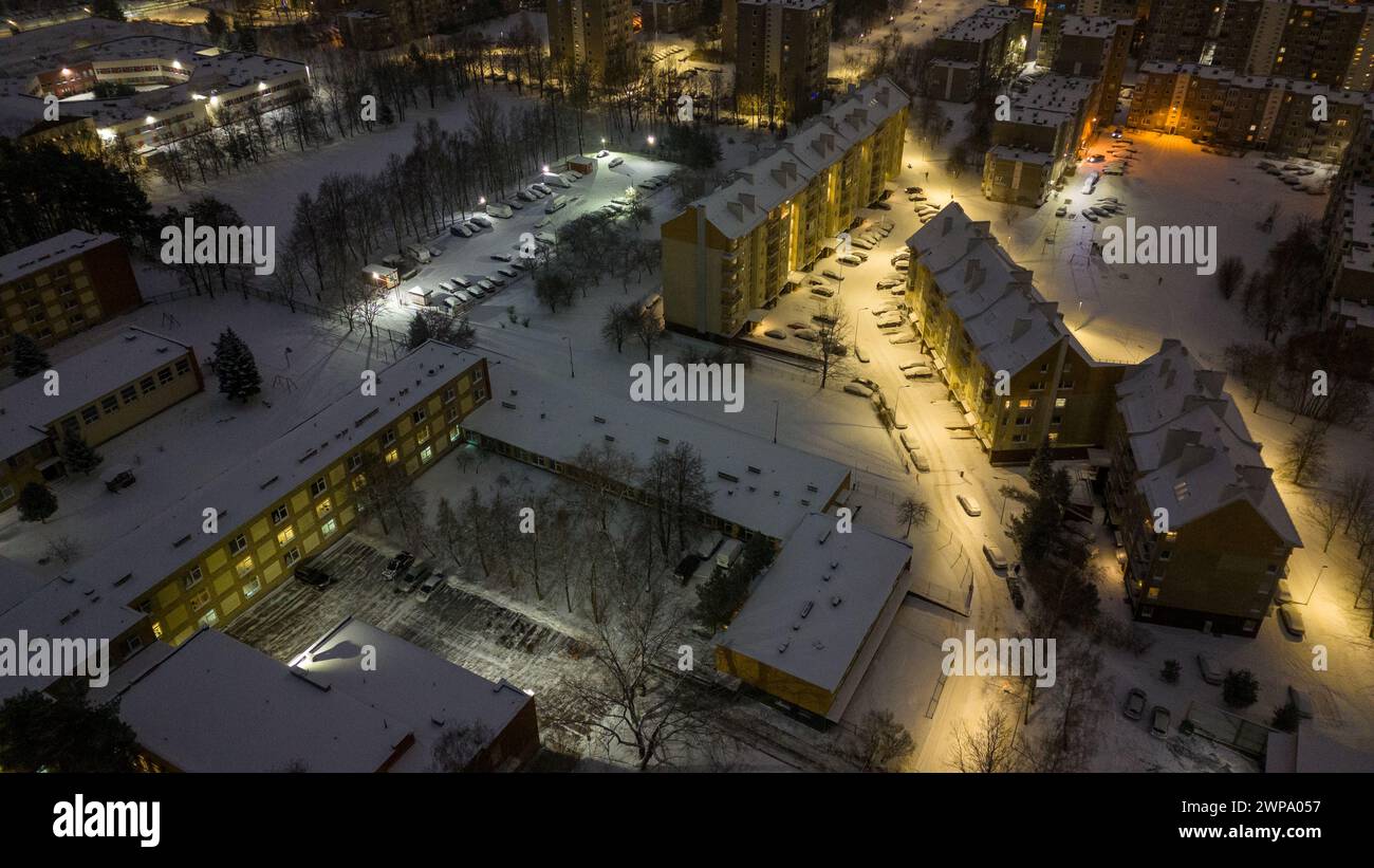 Fotografia con droni di appartamenti, strade e parcheggi coperti di neve durante la mattina nuvolosa d'inverno Foto Stock